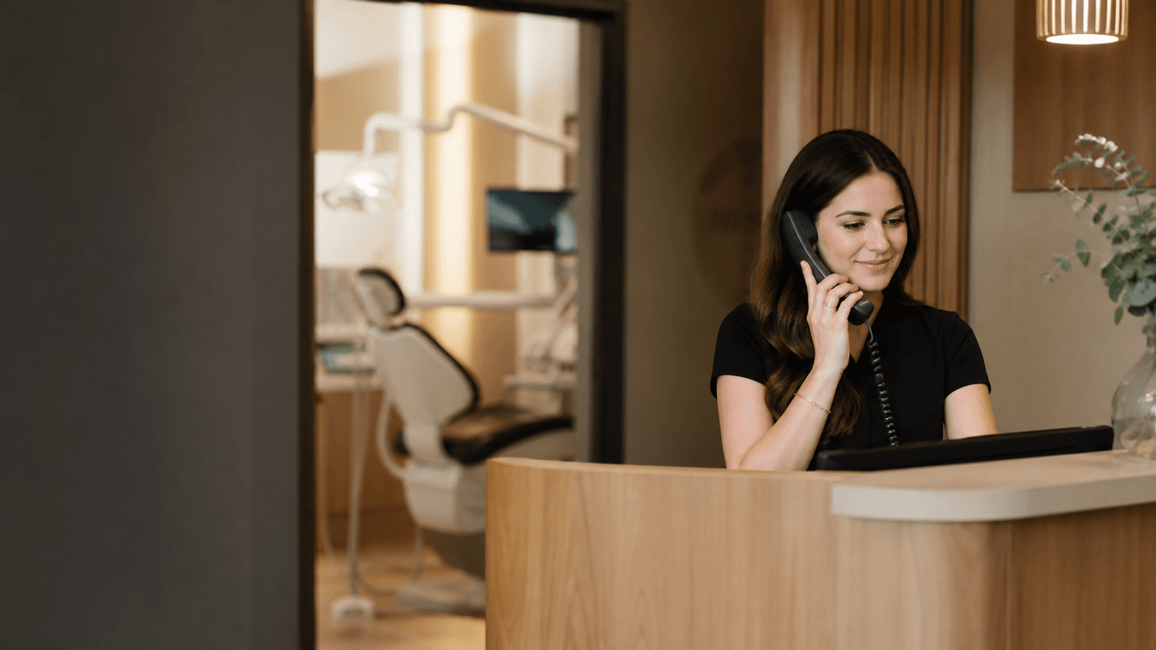 Dental practice manager handling appointments at the front desk